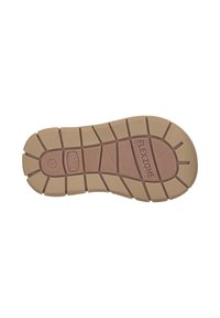 Gummisulor med en brun bottenfärg, strukturerad yta och olika mönster för grepp. Det finns en präglad detalj med texten "FLEXZONE".