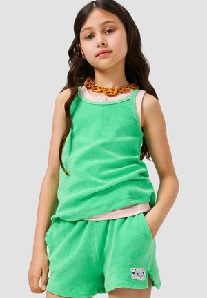 Set composto da canotta e pantaloncini in spugna verde con dettagli rosa. Collana notevole a forma di pretzel circolare. Tessuto morbido e vestibilità comoda.