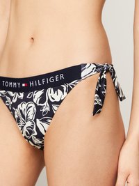 Tengerészhat színű bikini alsórész, fehér virágmintákkal, oldalt megkötős pántokkal és "TOMMY HILFIGER" logós, elasztikus derekkal.