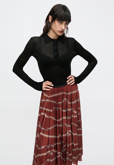 Must pikkade varrukatega särk kraega ja nööpidega, kombineeritud volditud roostes seelikuga, millel on kreemi värvi geomeetriline muster.