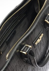 Zwarte leren handtas met een reliëf logo patroon; voorzien van gouden hardware, dubbele handvatten en meerdere binnenzakken met een gladde voering.