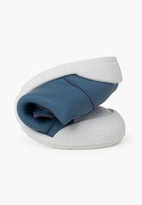 Chaussure en cuir bleu pliée, avec une semelle en caoutchouc blanc dotée de motifs de grip texturé. Tige lisse avec des détails de couture ton sur ton.