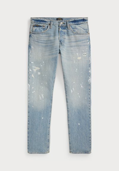 Jeans de denim azul claro com um ajuste relaxado, áreas desgastadas, respingos de tinta e um desbotamento subtil. Design padrão de cinco bolsos.