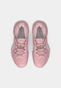 Αθλητικά παπούτσια σε ανοιχτό ροζ χρώμα με διχτυωτό επάνω μέρος, υφή σχεδίασης, έξι τρύπες για κορδόνια και αντίθεση γκρι και νεον κίτρινο εσωτερικό. Ελαφρύ πέλμα.