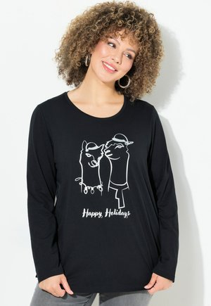 Camisa negra de manga larga con llamas dibujadas a línea en blanco, llevando sombreros y luces de cuerda, con el texto "Felices Fiestas" debajo.