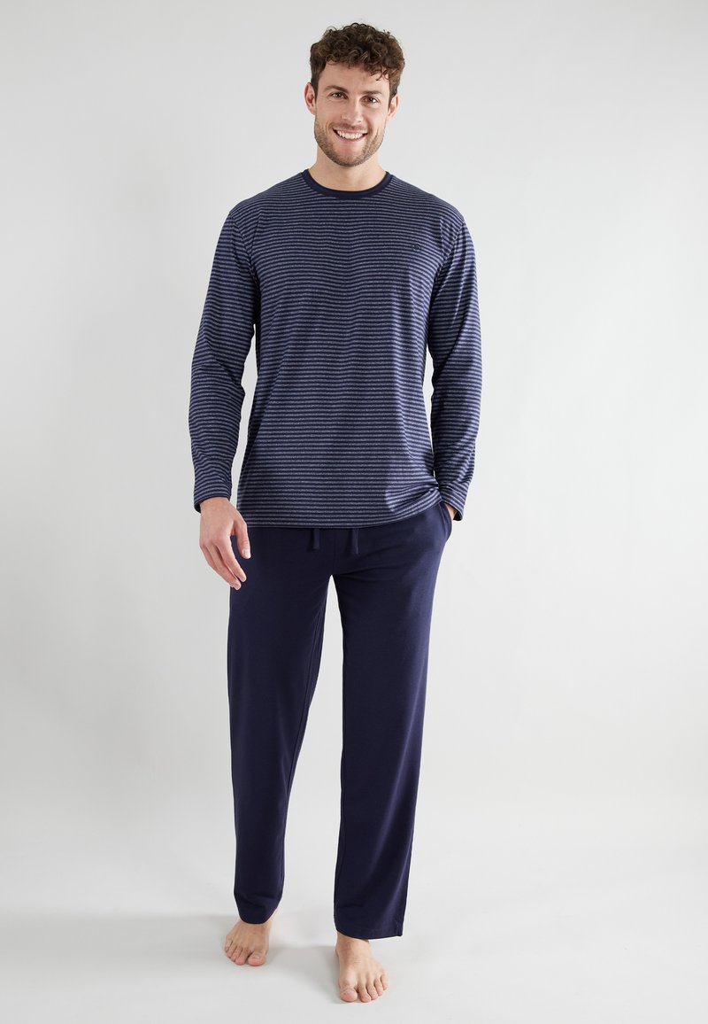 Navy striped long-sleeve shirt with rounded neckline and loose fit, paired with soft navy drawstring pants in a relaxed style.