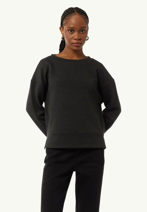 Black sweatshirt with textured geometric pattern, wide neckline, and dropped shoulders, paired with black pants. Smooth fabric finish.