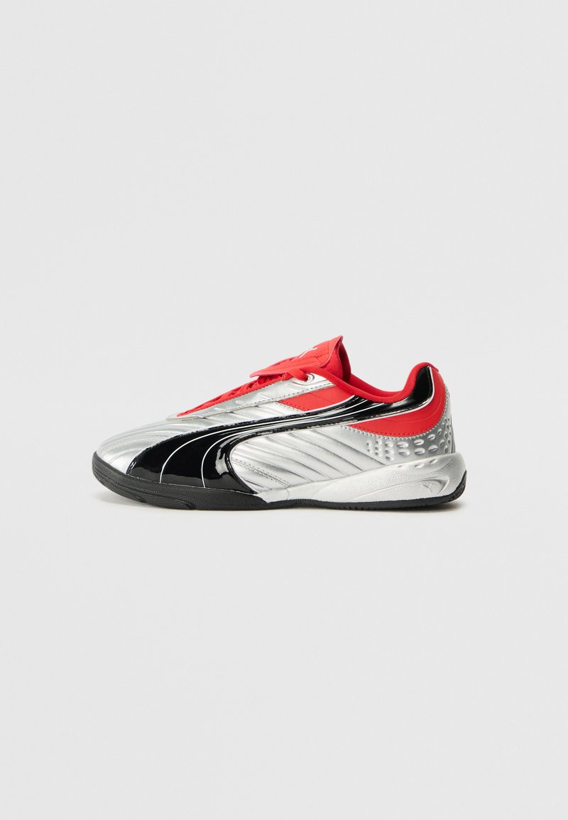 Scarpa sportiva rossa, argento e nera con una texture lucida. Presenta un design low-top, chiusura con lacci e dettagli laterali texture.