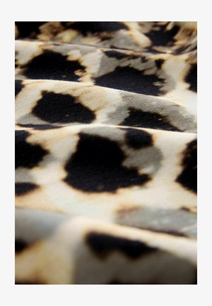 Leopardi mustriga kangas, mis koosneb mustade laikude ja heleda beeži tausta segust, millel on pehme tekstuur ja lainelised voldid.