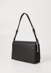 Czarna skórzana torba na ramię o płaskim designie, z regulowanym paskiem i subtelną teksturą. Charakteryzuje się smukłą sylwetką i srebrnymi akcentami metalowymi.