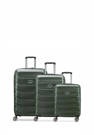 Three green hard-shell suitcases in varying sizes, featuring a textured design, extendable handles, and four wheels for mobility.
