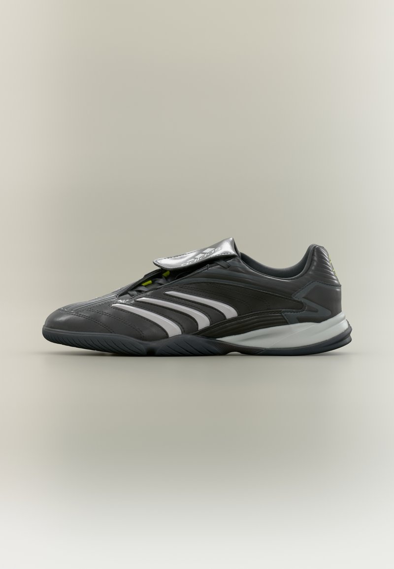 Γκρι αθλητικό παπούτσι με λευκές ρίγες, διαθέτει υφασμάτινο επάνω μέρος με υφή, μαλακή γλώσσα και καμπυλωτή σόλα για σταθερότητα. Μίνιμαλ σχεδιαστικές λεπτομέρειες.