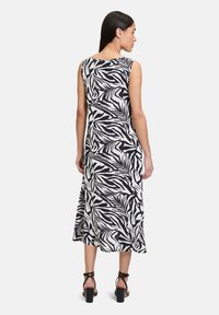Ärmelloses Maxikleid im Schwarz-Weiß-Zebra-Print, mit rundem Ausschnitt und fließender Silhouette. Textil mit einer weichen Drapierung.
