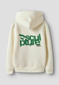 Una felpa con cappuccio color crema presenta un grande design grafico testuale verde sul retro, con la scritta "Sculpture Collective" e altri dettagli testuali.
