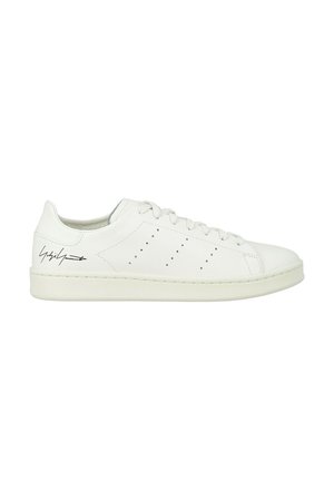 Sneaker bianca in pelle con punta rotonda, chiusura con lacci, sottili perforazioni sui lati e suola in gomma bianca testurizzata.