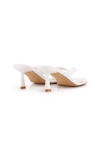 Sandalias blancas de tacón alto con un acabado liso y brillante, que presentan correas delgadas y un tacón diseñado de manera única con un acento marrón contrastante.