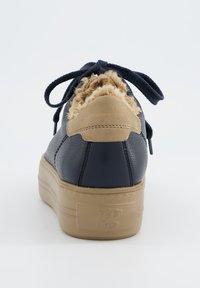 Baskets en cuir bleu marine avec accents en daim beige, doublure moelleuse texturée, bout rond, et semelle en caoutchouc plate ornée d’un petit logo.