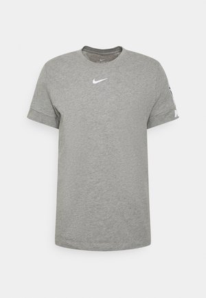 Hellgraues Nike T-Shirt mit kurzen Ärmeln, weißem Swoosh-Logo in der Mitte der Brust und Branding am linken Ärmel vor einfarbigem Hintergrund.