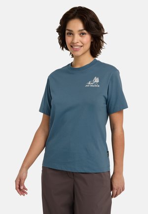Blauwe T-shirt met korte mouwen, gemaakt van katoen, met een witte grafiek van bomen en een tent op de linkerkant van de borst. Eenvoudig ontwerp met ronde hals.
