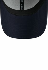 Granatowa czapka z jednolitą tkaniną z przodu i oddychającą siateczką z tyłu. Zawiera płaski daszek oraz subtelne detale w postaci przeszyć na brzegach.