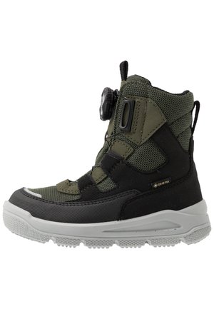 Grüne und schwarze wasserdichte Stiefel aus strukturiertem Material, mit gekrümmter Sohle, schnörkellosem Design mit einem Drehverschluss und verstärkter Zehenpartie für Langlebigkeit.