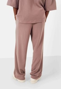 Luftige, rosa Loungewear-Hosen aus weichem Stoff. Mit gerader Silhouette, elastischem Taillenbund und schlichtem Design.