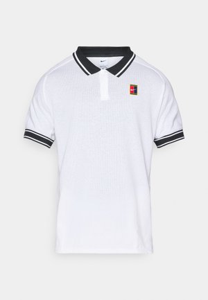 Witte Nike polo met een zwarte kraag en mouwstrepen, voorzien van een klein meerkleurig Nike-logo op de linkerborst.