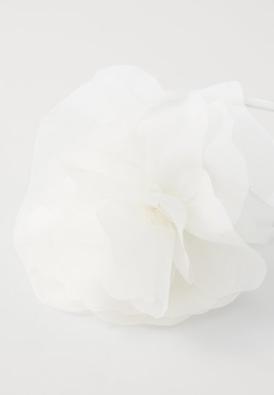 White fabric flower with layered petals, featuring a soft, sheer texture and a central fabric gathering, suitable for decorative use.