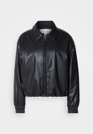 Zwarte cropped jacket van faux leer met een ritssluiting aan de voorkant, puntige kraag en elastische manchetten. Bevat minimale branding op de borst.