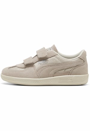 Beiger Wildleder-Puma-Sneaker mit doppelten Klettverschlüssen, strukturierter Sohle und gebrandeten Seitendetails vor weißem Hintergrund.