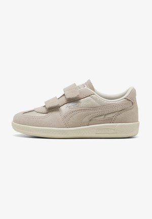 Beżowy zamszowy sneaker Puma z podwójnymi paskami na rzep, teksturowaną podeszwą i ozdobnymi detalami po boku na białym tle.