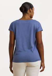 Μπλε κοντομάνικο τοπ με λεία υφή και χαλαρή εφαρμογή. Στρογγυλή λαιμόκοψη και διακριτές ραφές στους ώμους.