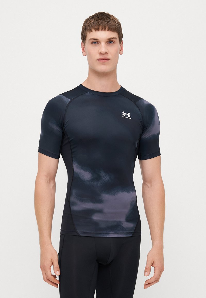 Short-sleeve athletic shirt in dark navy with a subtle purple pattern. Made of smooth, stretchy material. Features a crew neckline and logo.