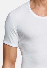 T-shirt bianco a maniche corte con scollatura rotonda e design aderente. Il tessuto appare liscio e leggermente elastico.