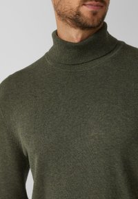 Zielony golf wykonany z miękkiej dzianiny, o dopasowanym kroju z prążkowanym kołnierzem i gładką fakturą.
