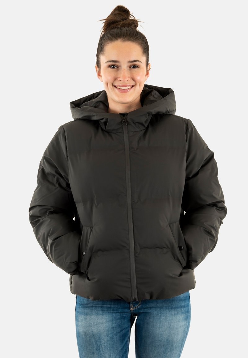 Sort dunjakke med hætte, der har lynlås, to sidelommer og en oppustet tekstur, vist på en smilende model.