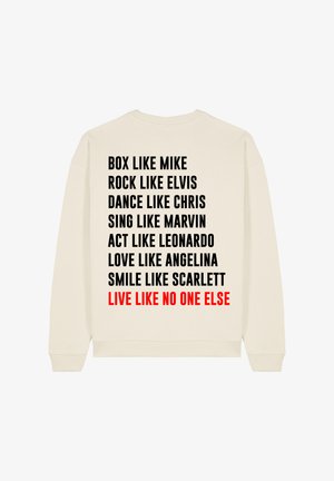 Sweatshirt crème à manches longues avec un dos orné de texte noir et rouge en grandes lettres, répertoriant diverses phrases en format colonne.