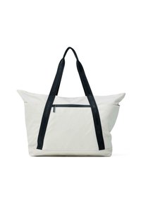 Liela balta somiņa ar melniem auduma rokturiem, ar rāvējslēdzēja kabatu priekšpusē un mīkstu, strukturētu dizainu.