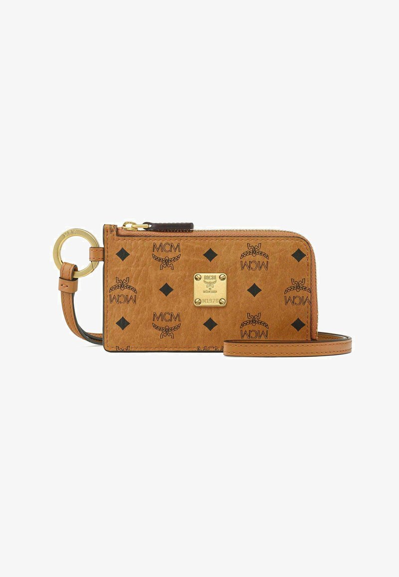 Bracelet MCM en cuir marron avec motif logo noir, fermeture éclair, plaque logo dorée et porte-clés doré attaché.