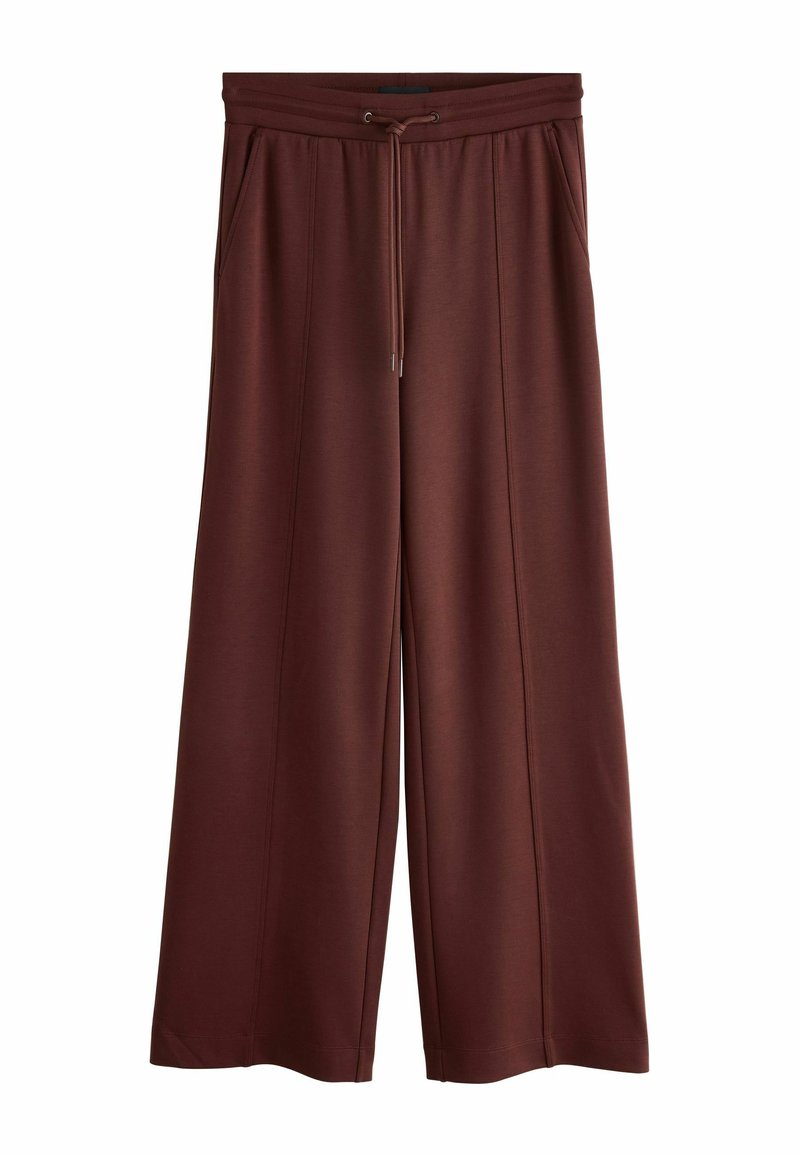 Pantaloni maro, largi, din material moale. Au talie elastică cu șnur, două buzunare laterale și cusături subtile.