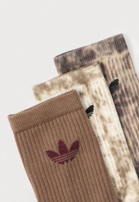 Trys poros įgulos kojinių: rudos, smėlinės su raštais ir pilkos margintos. Kiekvienoje kojinėje yra briaunuota tekstūra ir logotipo emblemą.