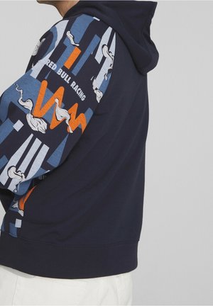 Sudadera navy con manga azul estampada con formas abstractas, acentos en blanco y texto "Red Bull Racing". Tejido suave y puños acanalados.