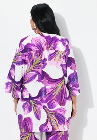 Blomstret kimono med store lilla og hvide blomstermønstre, med grønne accenter og orange detaljer, lavet af letvægtsstof.