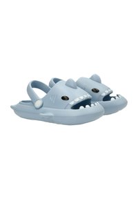 Chancletas de goma azules diseñadas para parecerse a un tiburón, con colmillos moldeados, aleta dorsal y detalles en los ojos. Diseño de punta abierta con correa trasera.