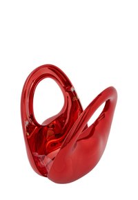 Rød, blank plastskulptur med glatte kurver, to åbninger til håndtag og en unik form, der ligner et stiliseret kar eller beholder.