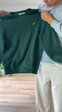 Σκούρο πράσινο φούτερ με στρογγυλή λαιμόκοψη, μακριά μανίκια και κεντημένο κίτρινο λογότυπο στο στήθος. Μαλακό ύφασμα με άνετη εφαρμογή.