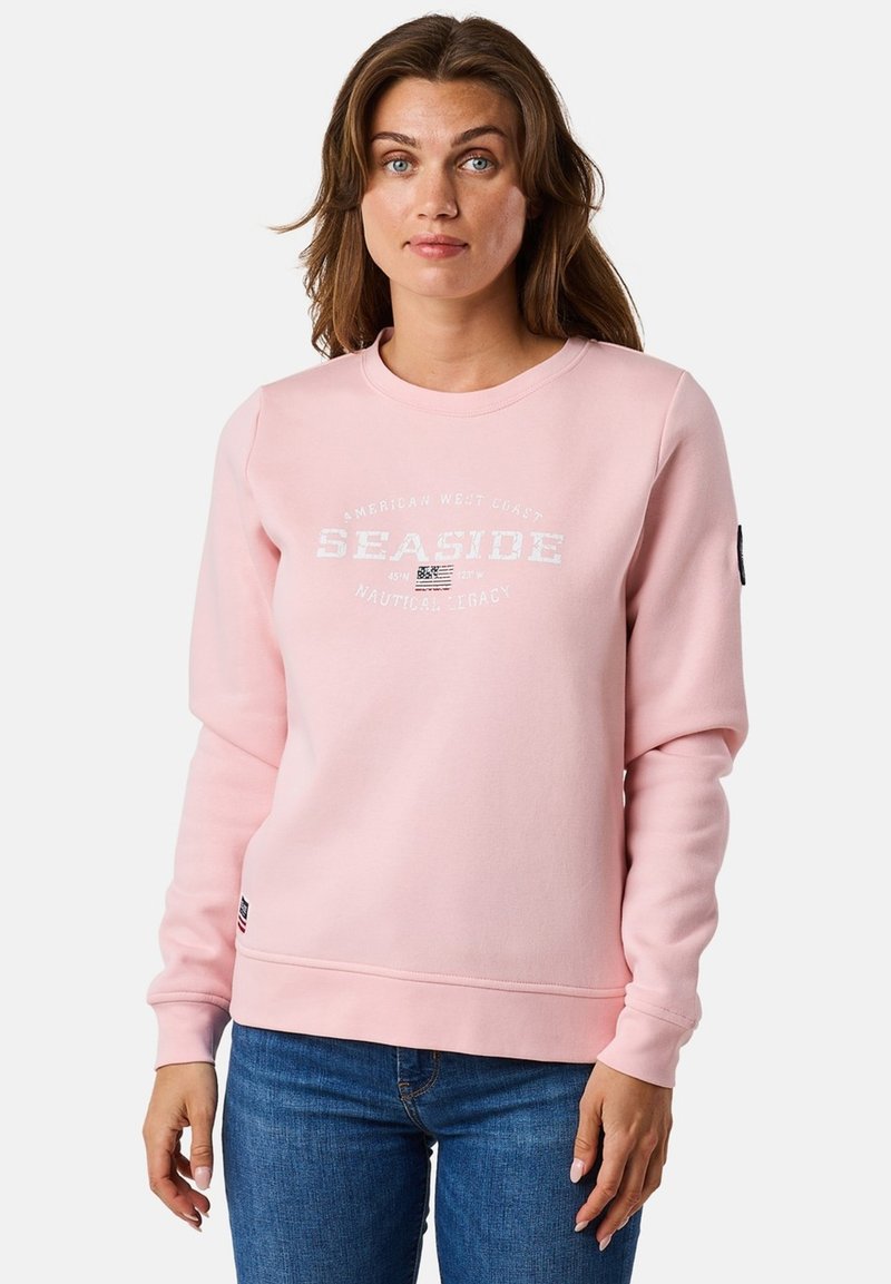 Felpa rosa chiaro con scollatura a girocollo, maniche lunghe e testo bianco "SEASIDE". Tessuto morbido con vestibilità rilassata e orlo a coste.