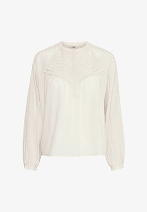 Bijela pamučna bluzica s dugim rukavima, okruglim izrezom i vezenim detaljima. Ima naborane detalje na prsima i reljefne uzorke na rukavima.