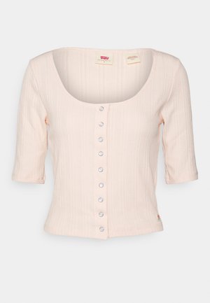 Haut rose clair côtelé à manches courtes avec encolure dégagée et rangée centrale de boutons-pression argentés, petite étiquette Levi's à l'ourlet.