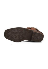 Sandal in pelle marrone con suola in gomma testurizzata caratterizzata da un motivo a zigzag, dettagli con fibbia regolabile e design piatto.